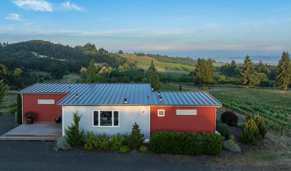 Bryn Mawr Vineyards Guest Cottage with red and silver siding overlooking scenic vineyard hills