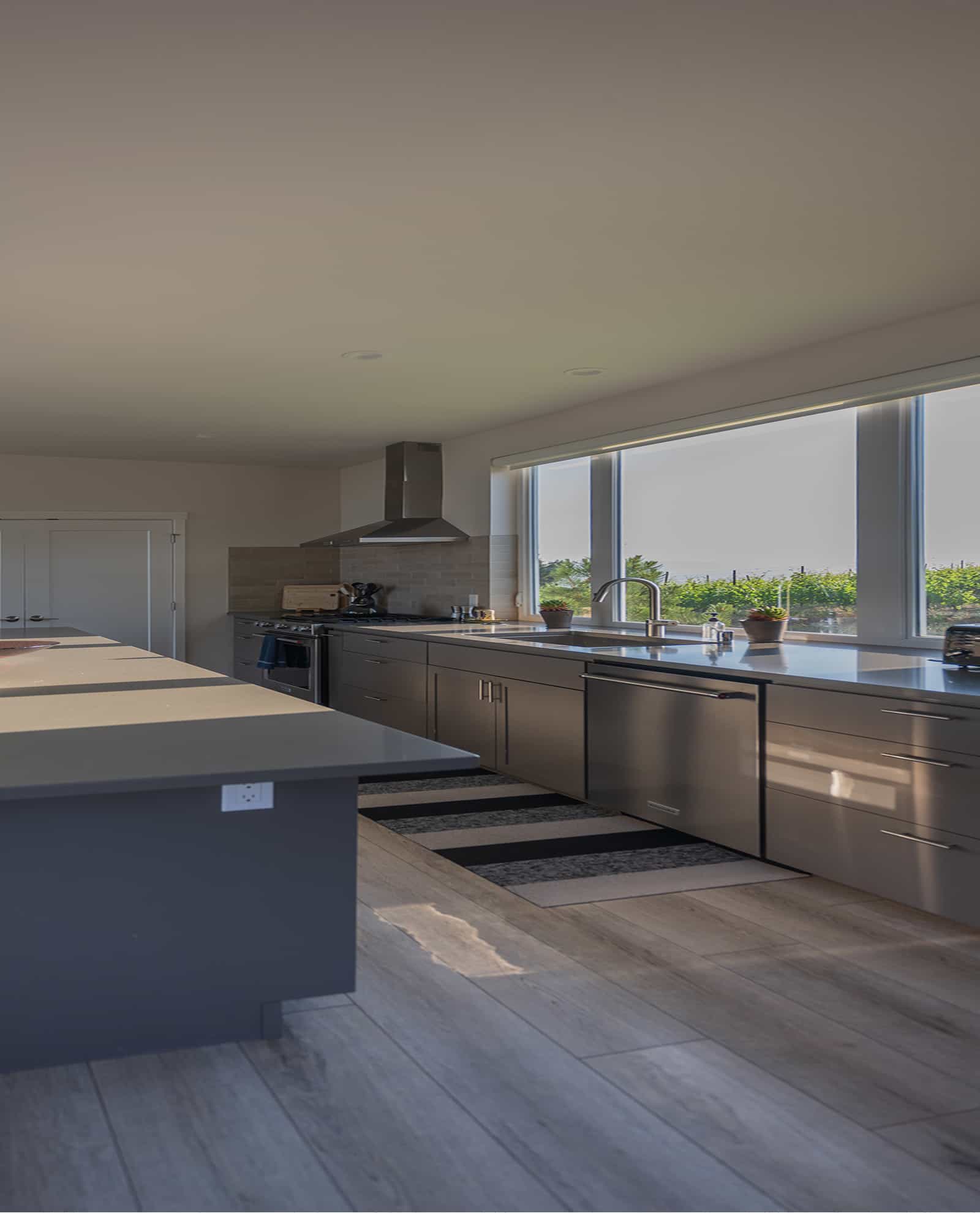 Bryn Mawr prefab home kitchen with long countertops stainless appliances and vineyard views through large windows