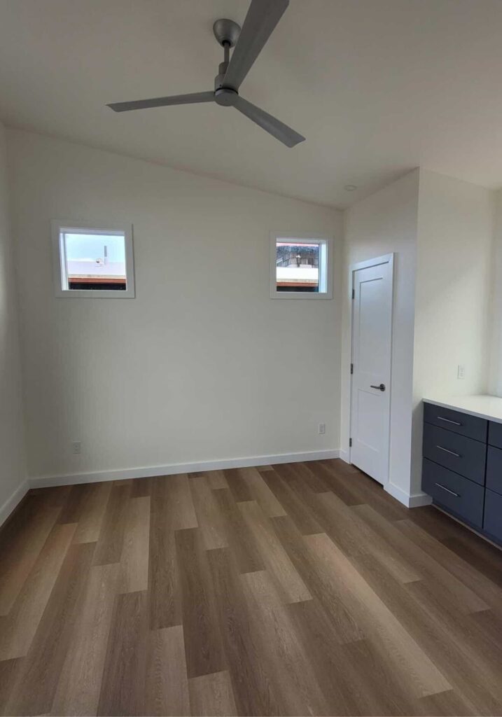 Cauthorn Beach Cottage interior with clean white walls wood flooring ceiling fan and built-in drawers