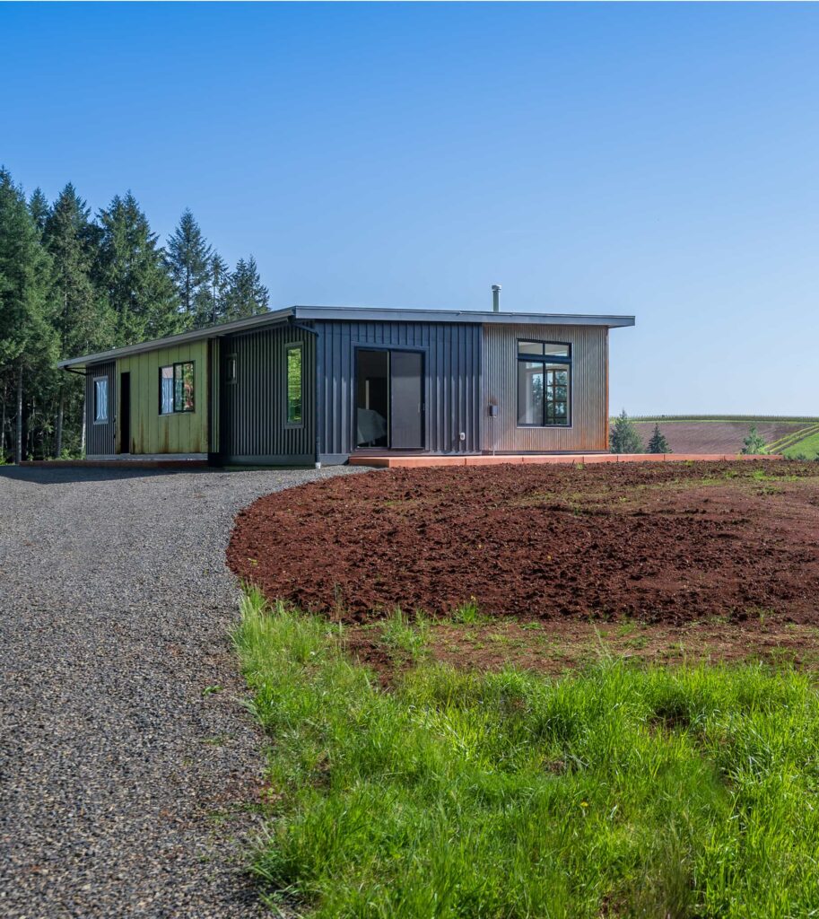 Exterior view of the guest cottage driveway and entrance, featuring sleek modern architecture and scenic vineyard surroundings.
