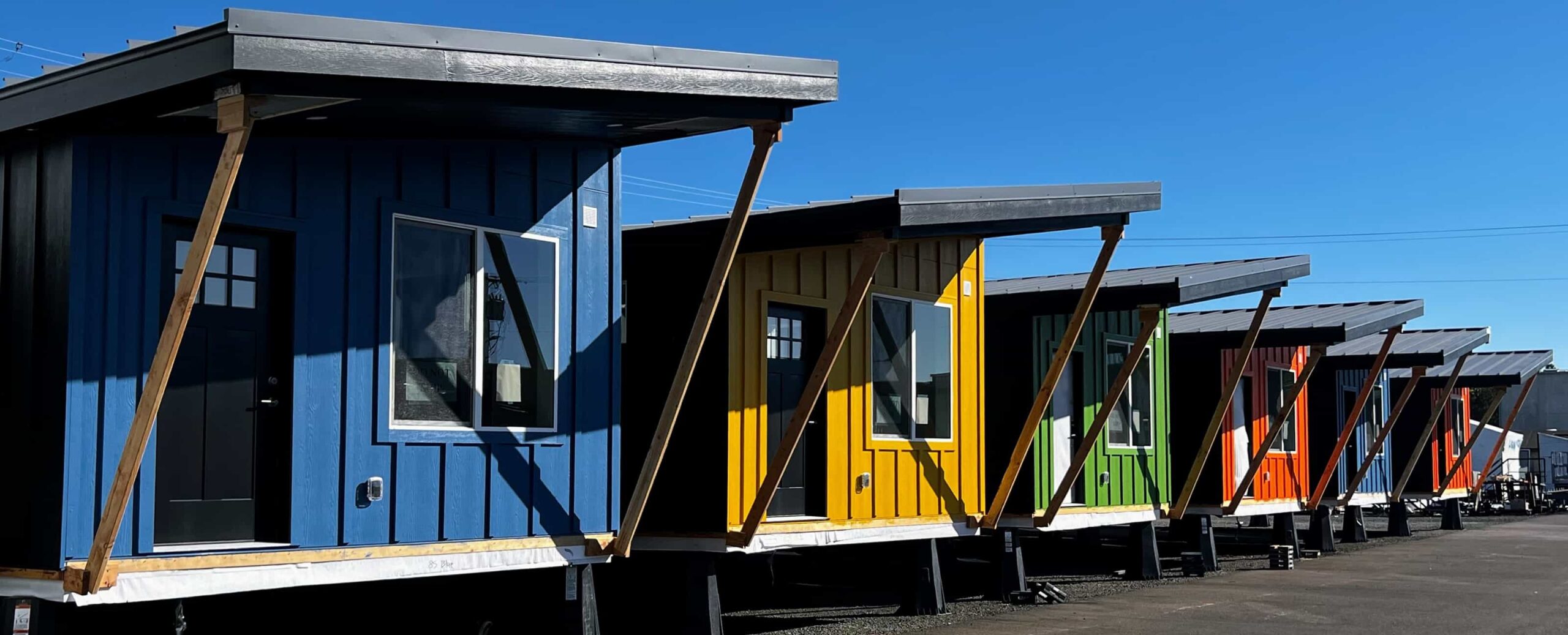 Row of colorful Ideabox modular homes lined up at the build site
