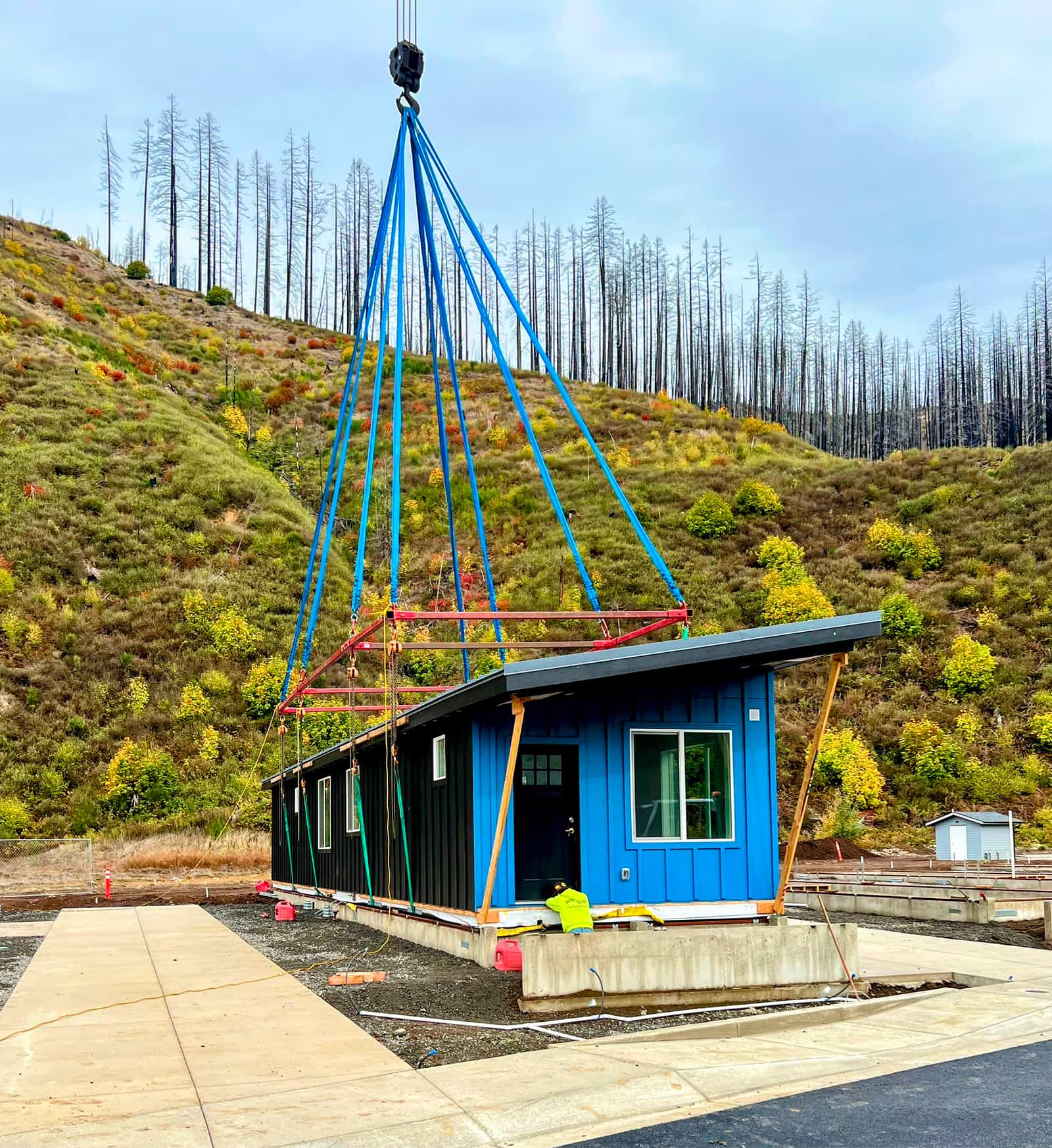 Blue Ideabox modular home lifted by crane during installation